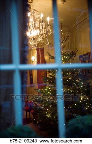 Interior of a house with a Christmas tree and a lamp chandelier seen from a street window. Soho, London, England, UK, Europe. View Large Photo Image Stock Photo - Interior of a house with a Christmas tree and a lamp chandelier seen from a street window. Soho, London, England, UK, Europe.. Fotosearch