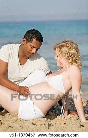 Stock Photo - Interracial couple at the beach. Fotosearch