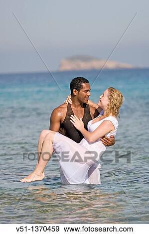 Stock Photo - Interracial couple at the beach. Fotosearch