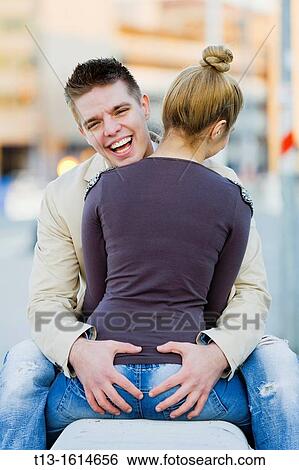 Intimate touch happy young couple on a bench View Large Photo Image Stock Photograph - Intimate touch happy young couple on a bench. Fotosearch