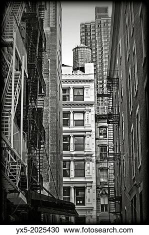 Stock Image - Iron fire escape stairs and balconys on the facade of a building in SoHo RE of New York City.. Fotosearch