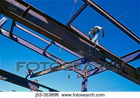 Stock Photograph - Ironworkers hanging structural steel. Oakland, California. USA.. Fotosearch