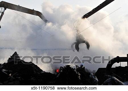 Stock Photo - Israel, Haifa Bay Industrial zone, Firefighters fight a large fire in steel recycling complex? Chod Matachot? Near Aco, May 22, 2010,. Fotosearch