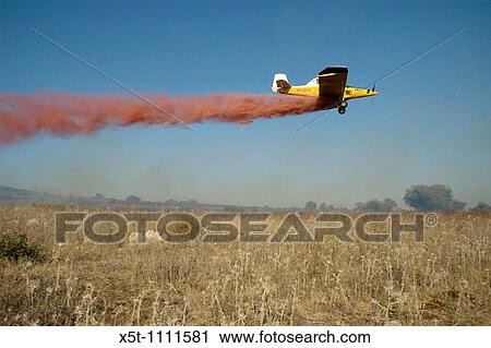 Stock Image - Israel, Haifa Carmel Mountain Forest, Aircraft dropping fire retardant on a wildfire. Fotosearch
