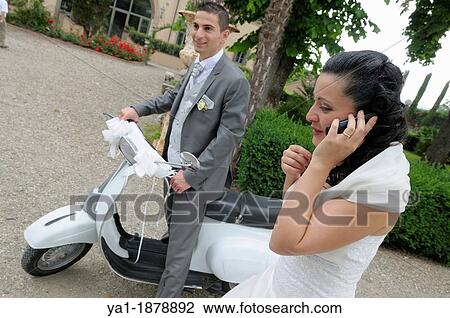Stock Image - Italian wedding couple with a motor scooter Vespa in a garden park, Firenze, Tuscany, Italy. Fotosearch