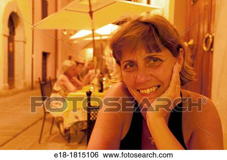 Italy, Umbria, Castiglione del Lago, Middle aged woman at dinner in outdoor restaurant View Large Photo Image Stock Photograph - Italy, Umbria, Castiglione del Lago, Middle aged woman at dinner in outdoor restaurant. Fotosearch