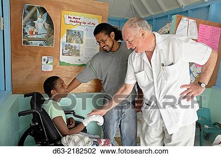 Stock Image - Jamaica. American Catholic missionary priest visiting sick children.. Fotosearch