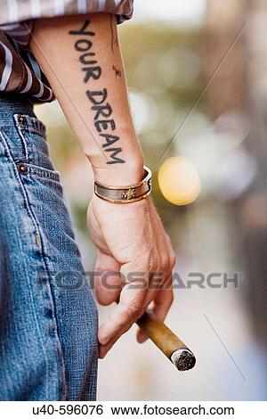 James de La Vega, street artist, tattoo on arm holding cigar. 8th Street. New York City. USA. View Large Photo Image Stock Photograph - James de La Vega, street artist, tattoo on arm holding cigar. 8th Street. New York City. USA.. Fotosearch