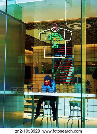 Stock Photo - Japanese girl sitting in a store window, Tokyo, Japan.. Fotosearch