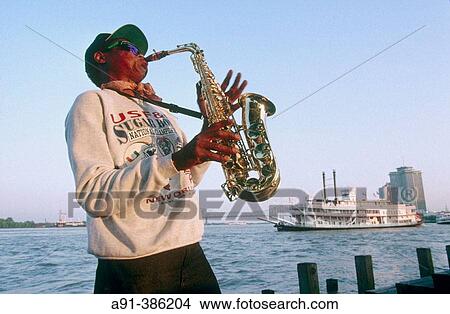 Jazz musician playing saxo on Mississipi bank and steamboat Natchez in background. Louisiana, USA View Large Photo Image Picture - Jazz musician playing saxo on Mississipi bank and steamboat Natchez in background. Louisiana, USA. Fotosearch