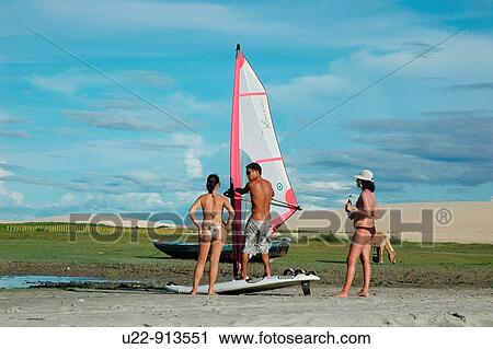 Jericoacoara (Ceara, Brazil): a guy teaching windsurfing to two tourists by the beach View Large Photo Image Stock Image - Jericoacoara (Ceara, Brazil): a guy teaching windsurfing to two tourists by the beach. Fotosearch