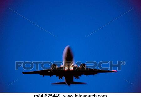 Stock Photo - Jet airplane in flight at dusk with motion effect. Fotosearch