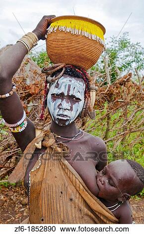 Stock Image - Jinka Ethiopia Africa village Lower Omo Valley Mago National Park wild tribe Mursi tribal portraits with paint on faces and traditional culture 15. Fotosearch