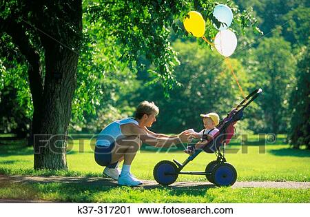 Jogger father playing ball with baby son sitting in stroller View Large Photo Image Stock Image - Jogger father playing ball with baby son sitting in stroller. Fotosearch