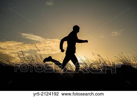 Jogger on beach at sunrise. Seaton Carew near Hartlepool, north east England, United Kingdom. Redcar steelworks in distance. View Large Photo Image Stock Image - Jogger on beach at sunrise. Seaton Carew near Hartlepool, north east England, United Kingdom. Redcar steelworks in distance.. Fotosearch