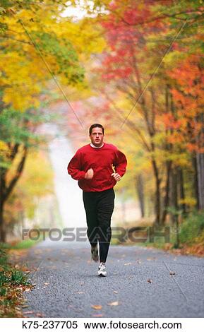 Jogger on country road View Large Photo Image Stock Photography - Jogger on country road. Fotosearch