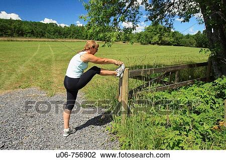 Jogger or runner stopping to stretch by a field and country road View Large Photo Image Stock Image - Jogger or runner stopping to stretch by a field and country road. Fotosearch
