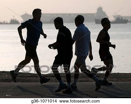 Picture - Joggers in ocean front park in Singapore. Fotosearch