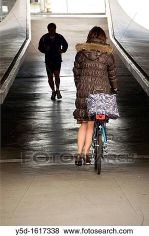 Stock Photo - jogging man and a woman on a bicycle, under the Mt Blanc bridge, Geneva, Switzerland. Fotosearch