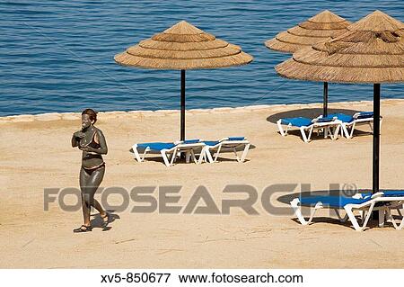 Jordan, Dead Sea Woman at Marriot Hotel beach with dead sea mud on her body View Large Photo Image Stock Photo - Jordan, Dead Sea Woman at Marriot Hotel beach with dead sea mud on her body. Fotosearch
