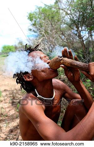 Ju/? hoansi San hunter sitting on the ground and smoking a pipe, Namibia, Africa. View Large Photo Image Stock Photography - Ju/? hoansi San hunter sitting on the ground and smoking a pipe, Namibia, Africa.. Fotosearch