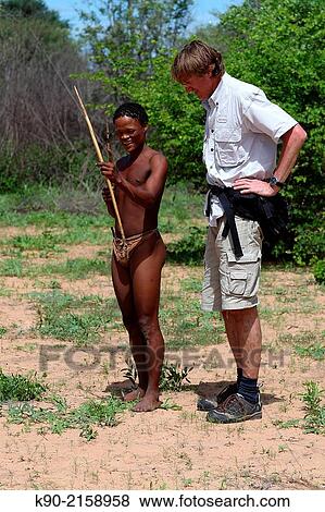 Ju/? hoansi San man explaining to tourist how to use bow and arrow, Namibia, Africa. View Large Photo Image Stock Photo - Ju/? hoansi San man explaining to tourist how to use bow and arrow, Namibia, Africa.. Fotosearch
