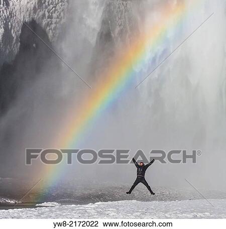 Stock Image - Jumping by Skogarfoss Waterfall in the Winter, Iceland.. Fotosearch