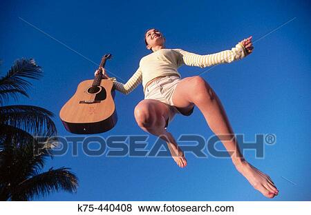 Jumping for joy with guitar in hand View Large Photo Image Stock Photo - Jumping for joy with guitar in hand. Fotosearch