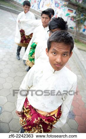Stock Image - Kathmandu Nepal Nepali boys stand waiting to practice a ceremonial dance in traditional Himalayan costumes in Nayapati Eastern Kathmandu 1.. Fotosearch