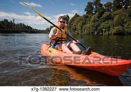 Stock Photo - Kayaking in the Arnold River outlet at Lake Brunner, South Island of New Zealand. Fotosearch