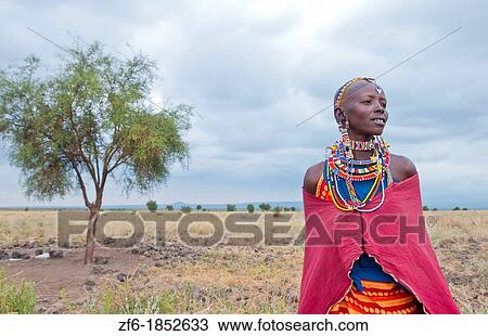 Kenya Africa Amboseli Maasai tribe village Masai woman in red costume dress and beads and tree in remote area of Amboseli National Park safari 1 View Large Photo Image Stock Image - Kenya Africa Amboseli Maasai tribe village Masai woman in red costume dress and beads and tree in remote area of Amboseli National Park safari 1. Fotosearch