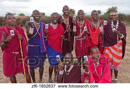 Kenya Africa Amboseli Maasai tribe village Masai group of men in red costume dress and beads holding Fuji Polaroids in remote area of Amboseli National Park safari 1 View Large Photo Image Stock Photo - Kenya Africa Amboseli Maasai tribe village Masai group of men in red costume dress and beads holding Fuji Polaroids in remote area of Amboseli National Park safari 1. Fotosearch