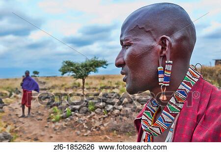 Kenya Africa Amboseli Maasai tribe village Masai man in red costume dress and beads close up of jewelry in remote area of Amboseli National Park safari 1 View Large Photo Image Stock Photograph - Kenya Africa Amboseli Maasai tribe village Masai man in red costume dress and beads close up of jewelry in remote area of Amboseli National Park safari 1. Fotosearch