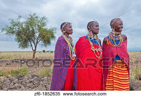 Kenya Africa Amboseli Maasai tribe village Masai women in red costume dress and beads and tree in remote area of Amboseli National Park safari 1 View Large Photo Image Stock Photography - Kenya Africa Amboseli Maasai tribe village Masai women in red costume dress and beads and tree in remote area of Amboseli National Park safari 1. Fotosearch