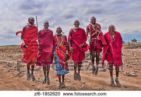 Stock Image - Kenya Africa Amboseli Masai men in red costume dress and beads in Amboseli National Park safari 1. Fotosearch