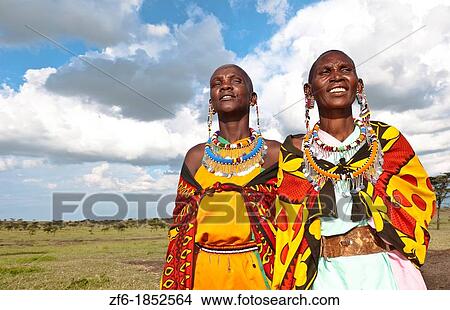 Kenya Masai Mara reserve with two Masai women in colorful dress with blue sky in Masai Mara National Park in reserve 10 View Large Photo Image Picture - Kenya Masai Mara reserve with two Masai women in colorful dress with blue sky in Masai Mara National Park in reserve 10. Fotosearch