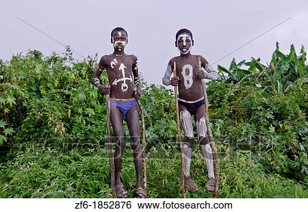 Key Afer Ethiopia Africa Bena boys Lower Omo Valley with white paint on chests on stilts with Bena Tribe dress 14 View Large Photo Image Stock Photograph - Key Afer Ethiopia Africa Bena boys Lower Omo Valley with white paint on chests on stilts with Bena Tribe dress 14. Fotosearch