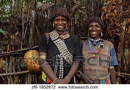 Stock Image - Key Afer Ethiopia Africa village Lower Omo Valley closeup of two Hamar or Hammer women traditional outfits and red hair portrait 14. Fotosearch
