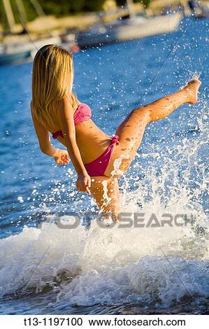 Kicking water young woman on the beach View Large Photo Image Stock Image - Kicking water young woman on the beach. Fotosearch