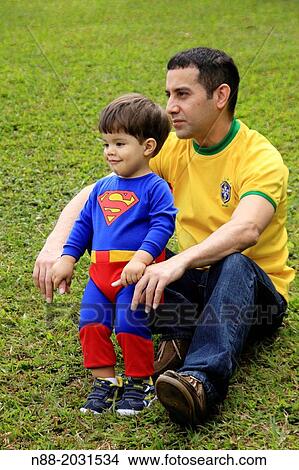 Kid in a superhero costume with dad. View Large Photo Image Picture - Kid in a superhero costume with dad.. Fotosearch