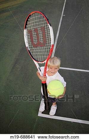 Kid with a giant tennis ball and racket View Large Photo Image Stock Image - Kid with a giant tennis ball and racket. Fotosearch