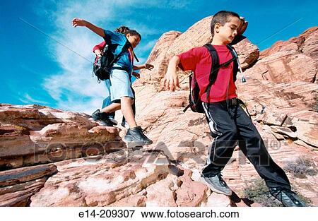 Stock Photo - Kids climbing on rocks. Nevada. USA. Fotosearch