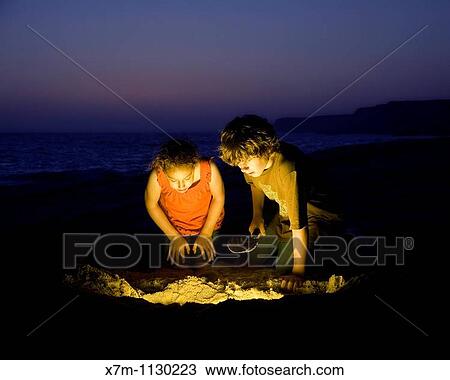 Kids find treasure after digging on a sandy beach View Large Photo Image Stock Image - Kids find treasure after digging on a sandy beach. Fotosearch