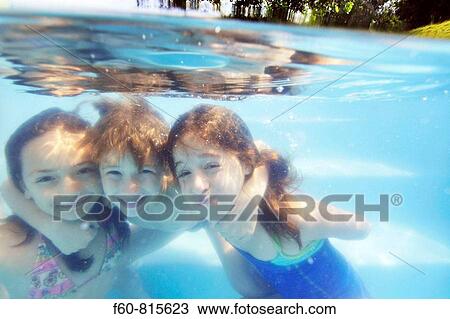 Stock Image - Kids having fun in the family pool, Guararema, Sao Paulo, Brazil. Fotosearch