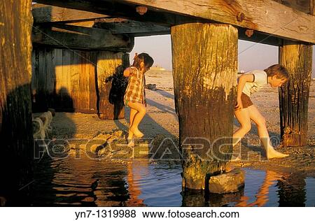 kids playing under the pier on a hot sunny afternoon View Large Photo Image Stock Photo - kids playing under the pier on a hot sunny afternoon. Fotosearch