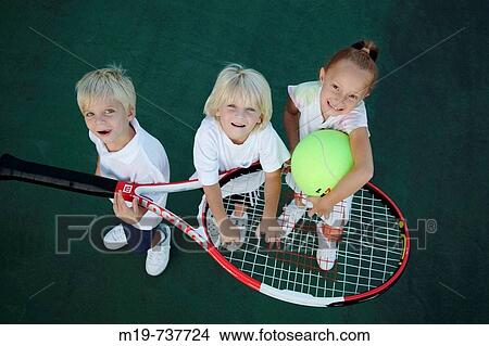 Kids playing with an oversized tennis racket and ball View Large Photo Image Picture - Kids playing with an oversized tennis racket and ball. Fotosearch