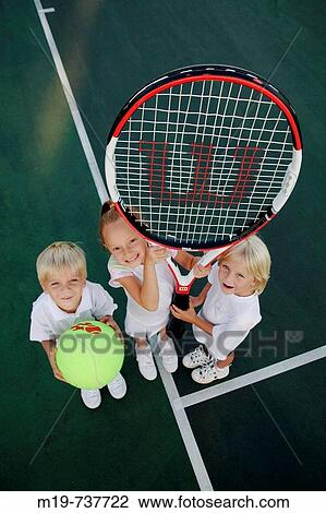Stock Image - Kids posing with an oversized tennis racket and ball. Fotosearch