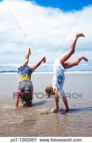 Kids somersalting on beach View Large Photo Image Stock Photo - Kids somersalting on beach. Fotosearch
