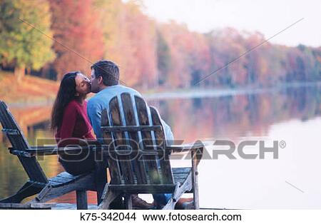 Kissing lakeside in chairs View Large Photo Image Picture - Kissing lakeside in chairs. Fotosearch