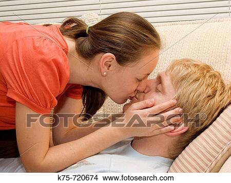 Picture - Kissing on the couch. Fotosearch